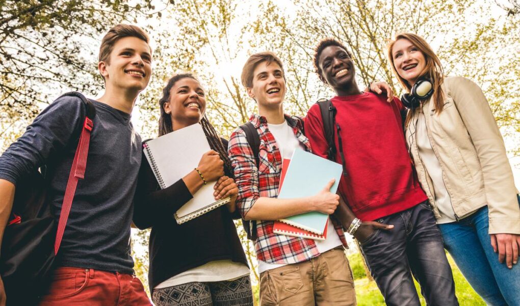 Group of teenagers holding folders of work.