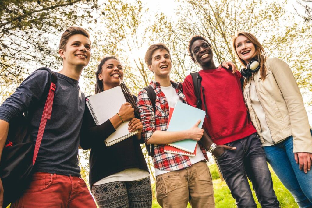 Group of teenagers holding folders of work.